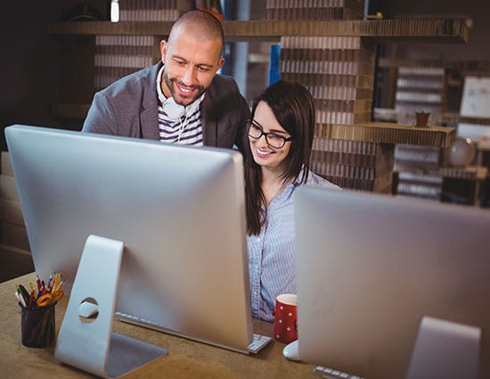 Two colleagues discussing something on a computer screen